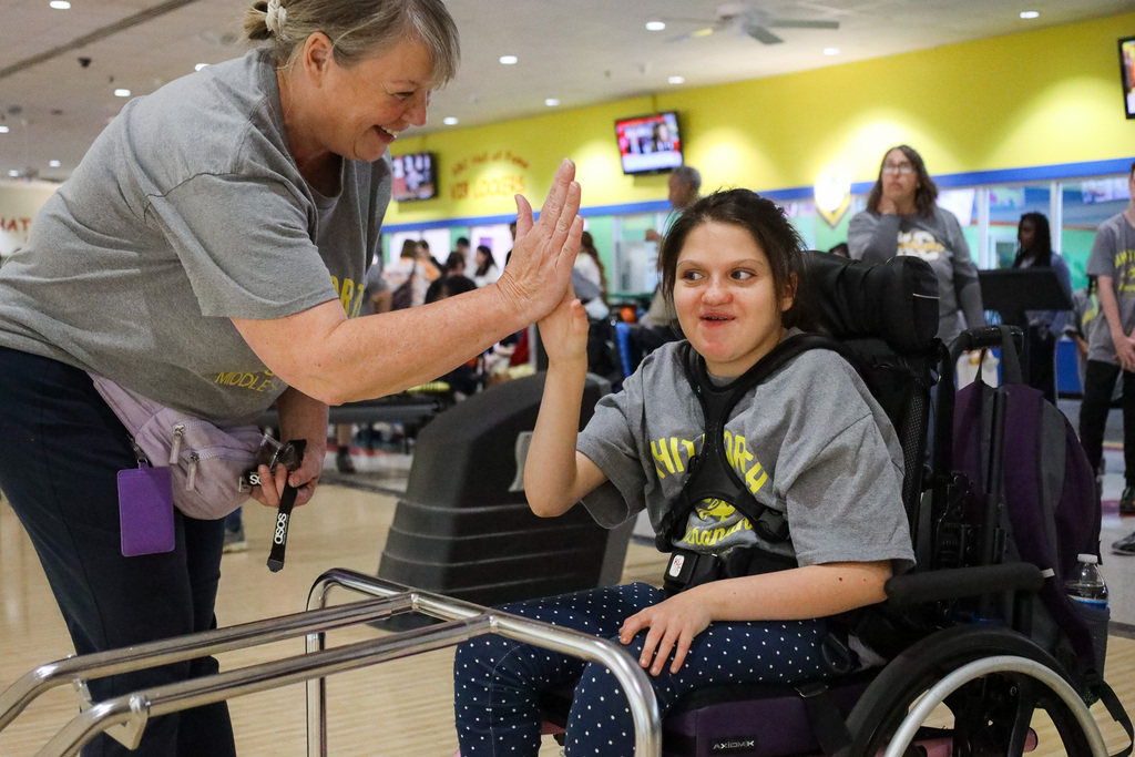 Staff member and student high fiving