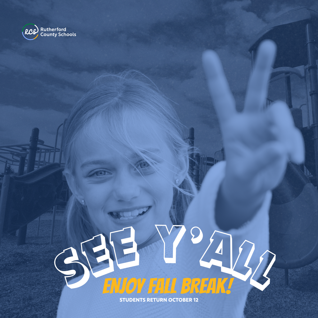 A smiling girl making a peace sign at a playground. The background shows a blurred playground.