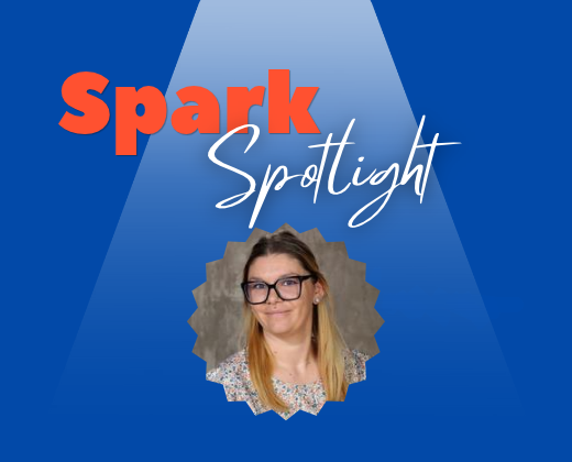 Bright blue background with spotlight effect. Text reads "Spark Spotlight". A woman in glasses is in a spotlight.