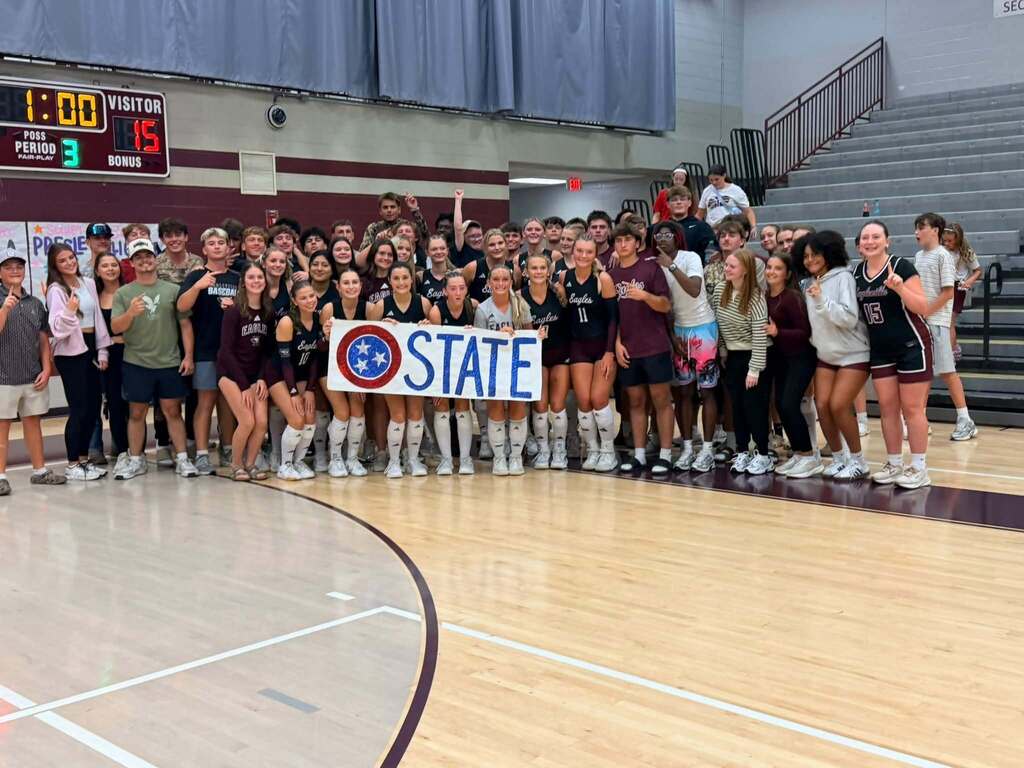 Eagleville volleyball team holding sign that says, "O State."