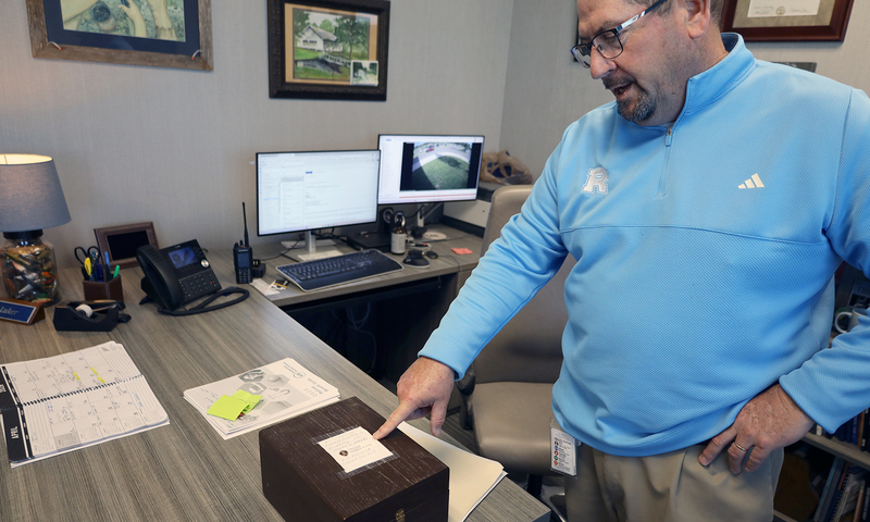 Principal Luker showing box containing student info cards from the early to mid 1900s