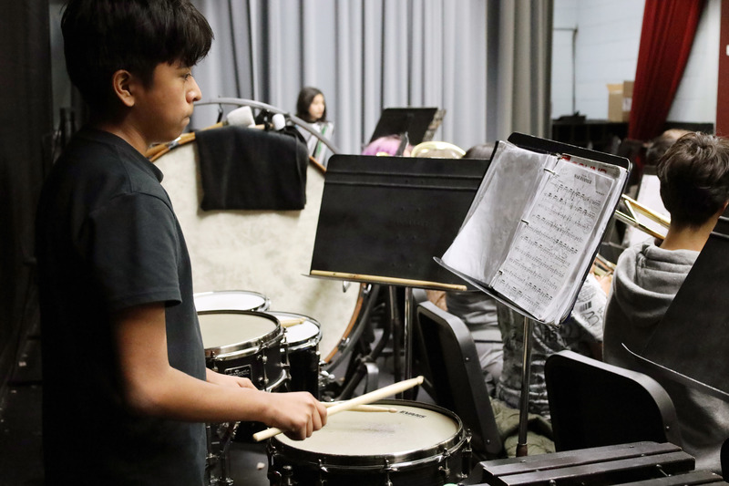 Boy practiving drums with sheet music