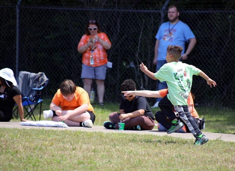 Boy in green shirt runds during game of kickball