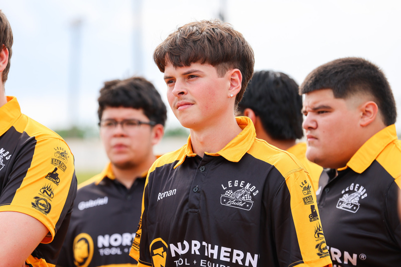 Students in black and yellow shirts stand in group