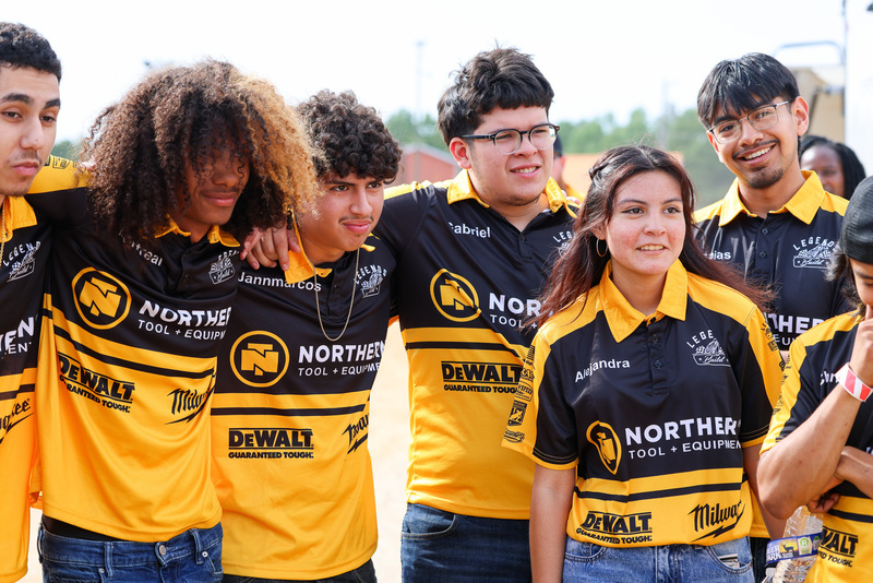 Students in black and yellow shirts stand in group