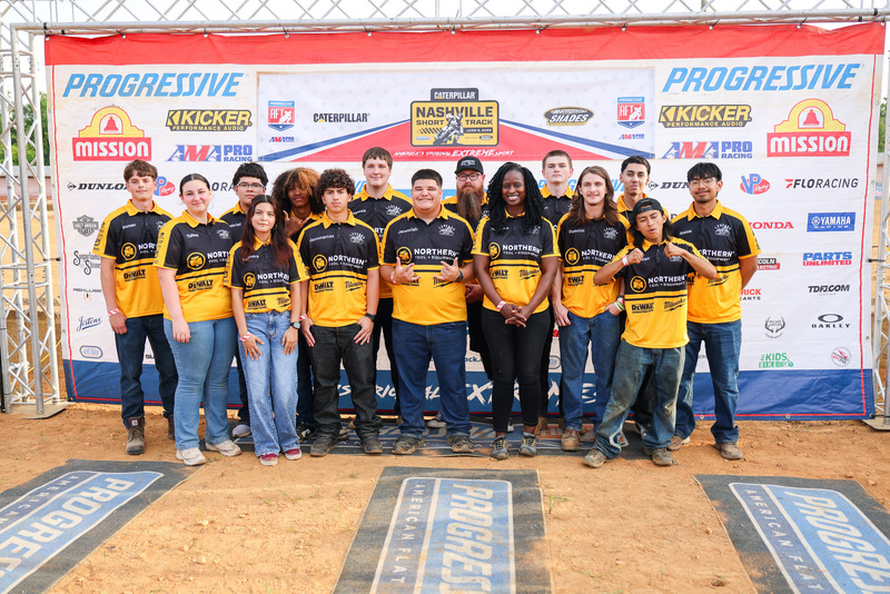 Students in black and yellow shirts stand in group