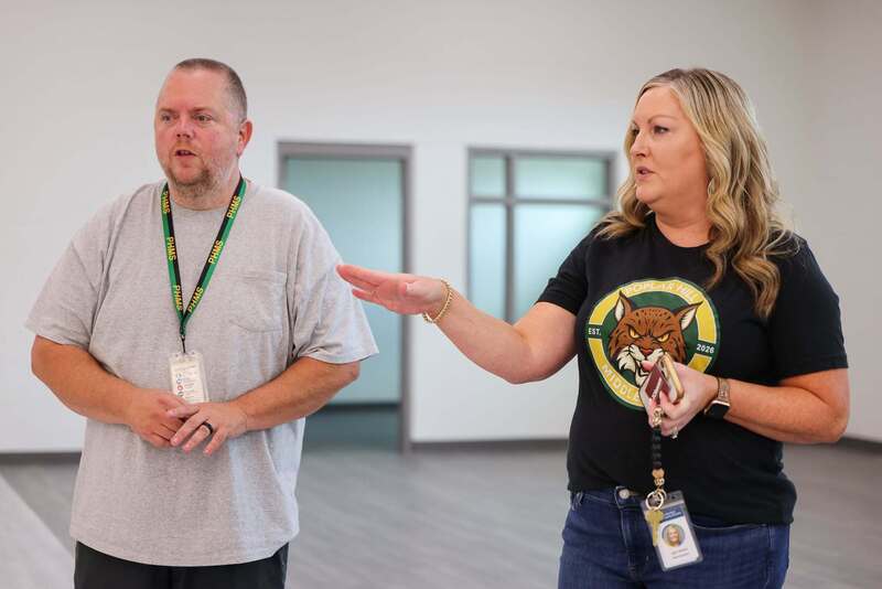 Man in gray shirt listens as woman in black shirt talks.