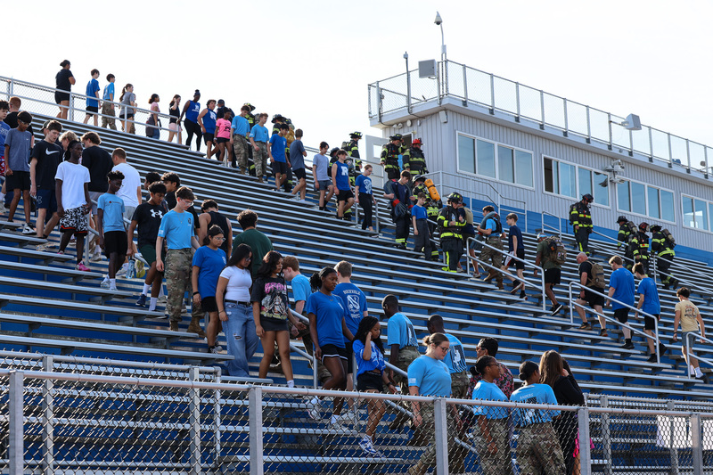 Students and fireman climbing stadium stairs