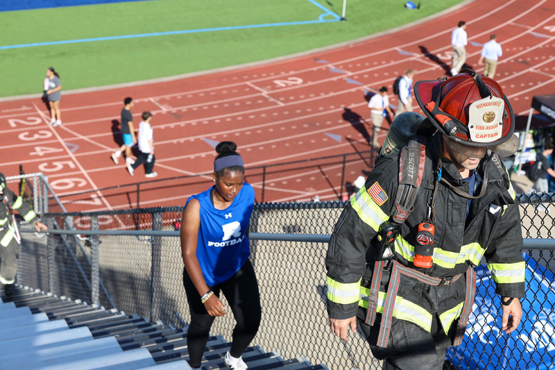 Students and fireman climbing stadium stairs