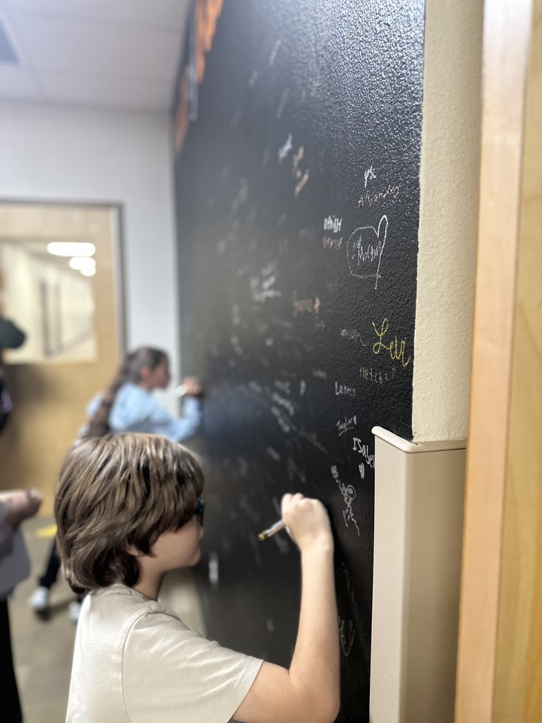 students signing their name on the wall