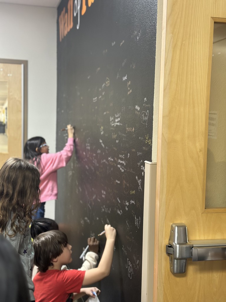 students signing their name on the wall