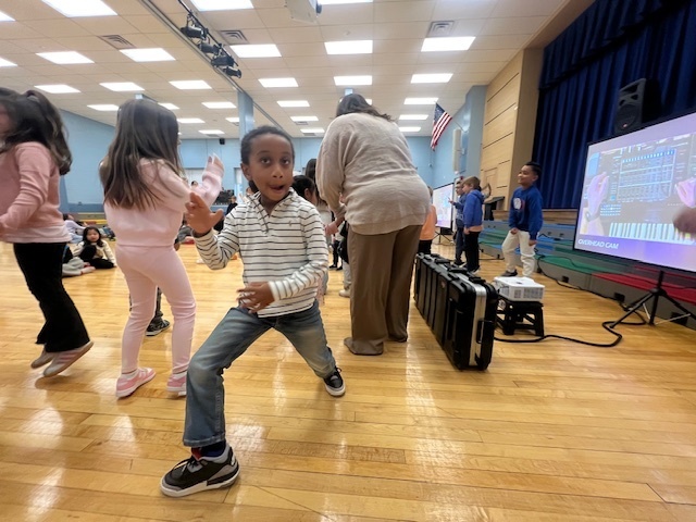 students dancing on the gym floor during assembly