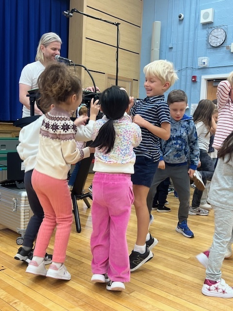 students dancing on the gym floor during assembly