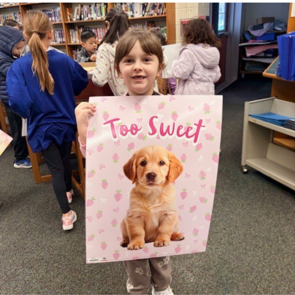 student with poster prize in library