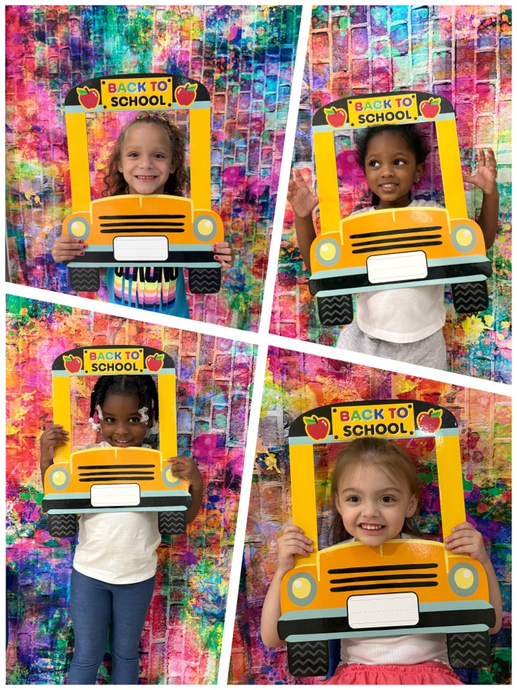 4 preschoolers with their faces in bus that says back to school 