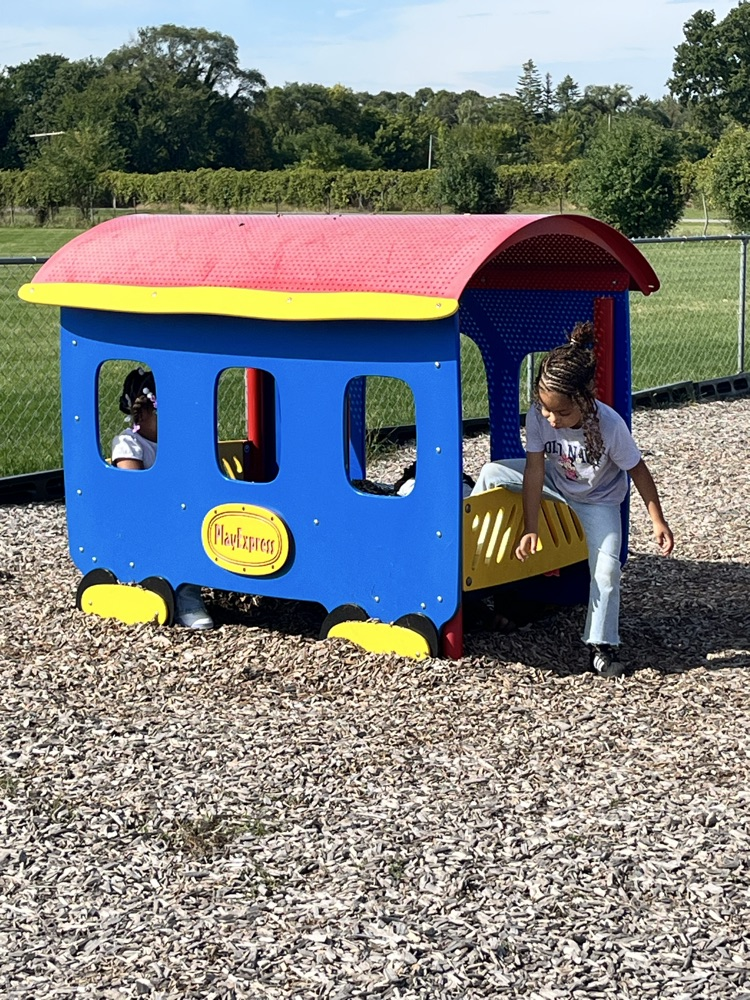 children playing in play train outside
