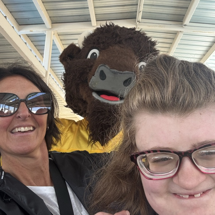 two adult females posing with the Buffalo Wild Wings mascot at the farmers market