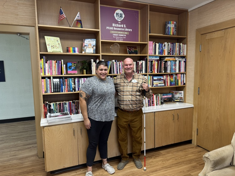woman standing next to man in front of a resource library