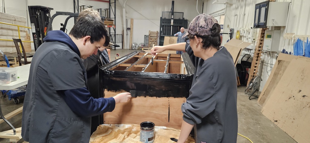 Students staining dresser