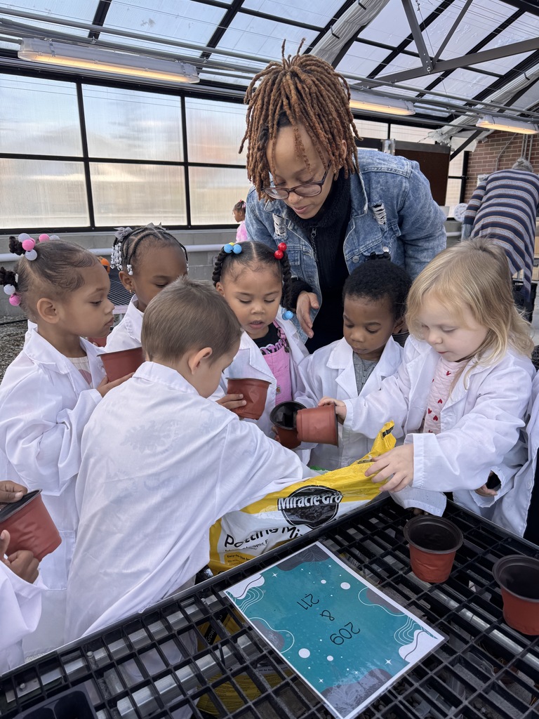 Students filling containers with soil in Jerome's greenhouse. 