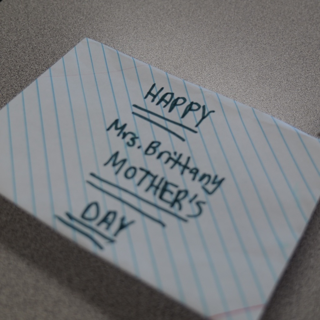 A folded paper with "HAPPY MOTHER'S DAY" written on it, addressed to Mrs. Brittany.