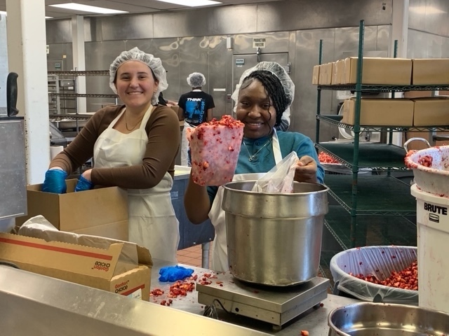 Two students filling containers of cranberries