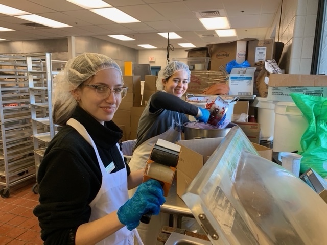 Two students helping to package cranberries