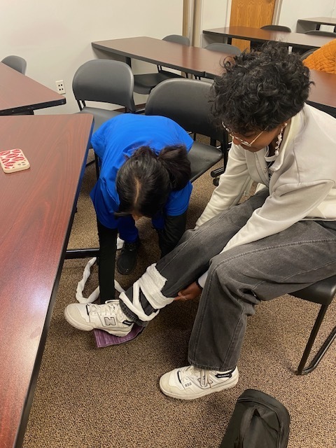 Student taping another students ankle
