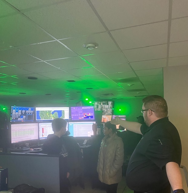 MMR representative showing two students the inside workings of their 911 call center