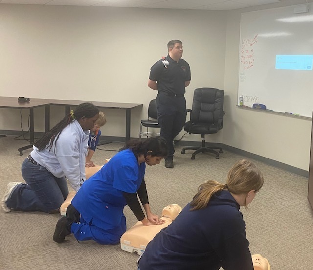 MMR trainer with 4 students doing CPR on mannequins