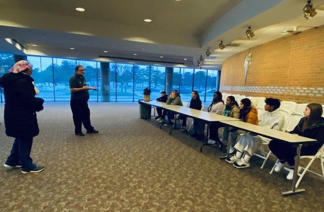 students sitting at a long table with an instructor