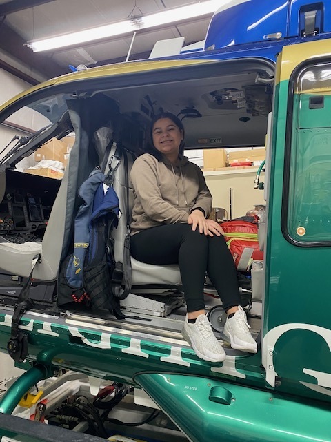 female student, all smiles, inside the helicopter