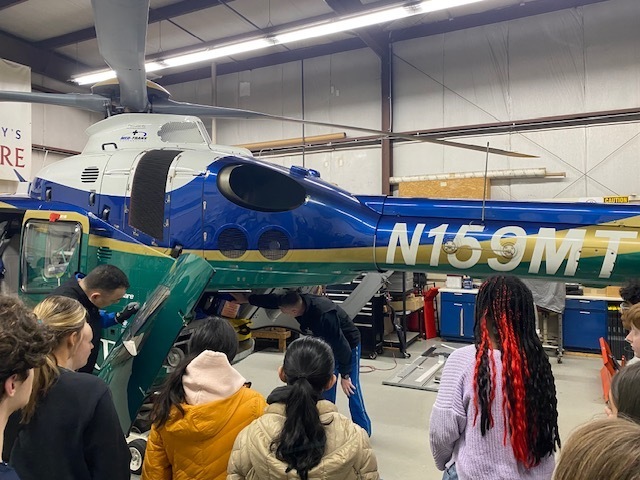 students checking out the backside of the helicopter