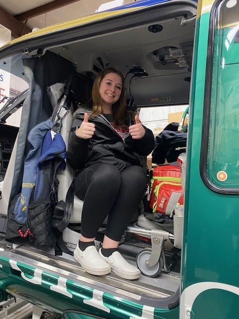 female student with thumbs up inside the helicopter