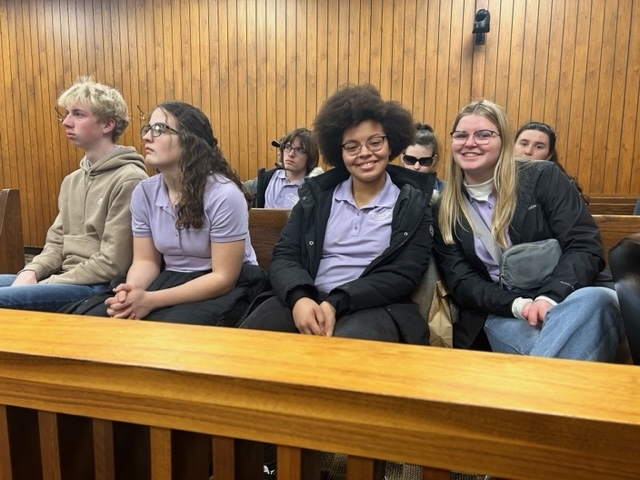 student ambassadors sitting in courtroom with smiles