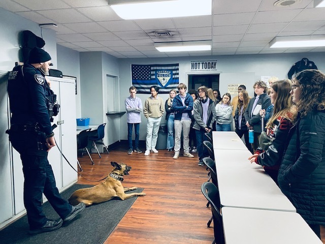 Ambassadors speaking to a city police officer and his canine Aries