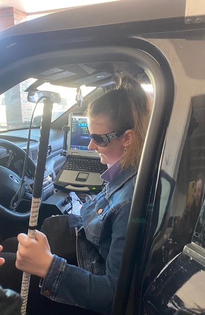 Student inside the front seat of a police car