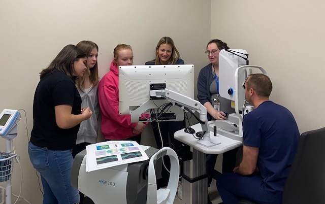 Students looking at a computer screen with two GLBH staff