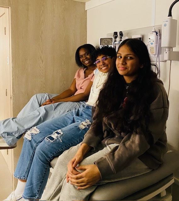 Three students smiling inside the GLBH Medical Mobile