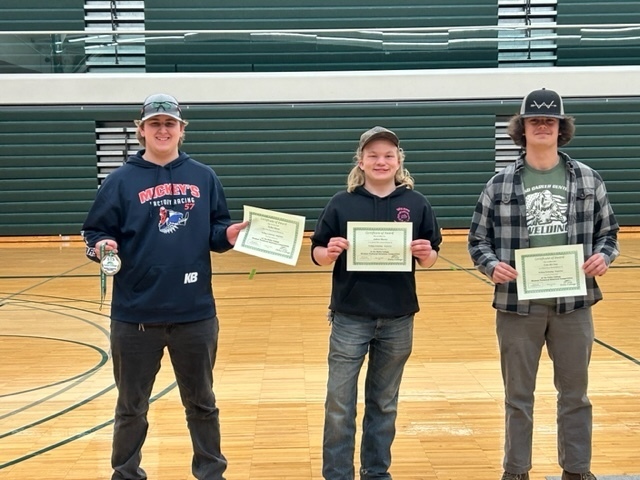 Three students with certificates