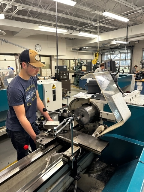 Male Student using a manual lathe