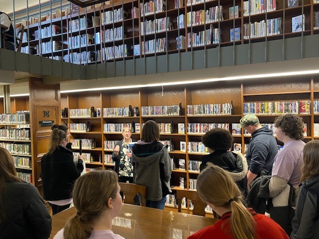 students in the library viewing the book shelves