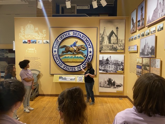 Castle Museum guide showing the students the Post Office emblem