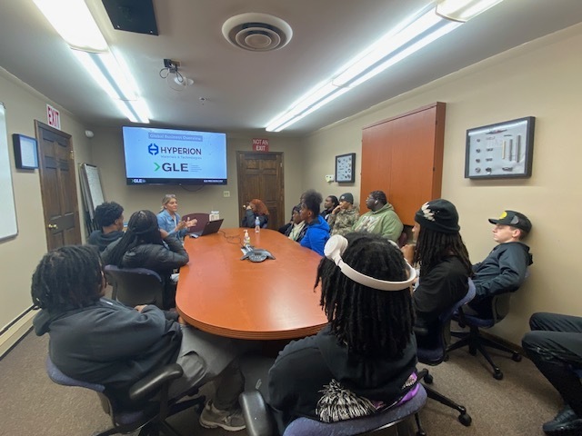GLE Representative talking to the students around a conference table