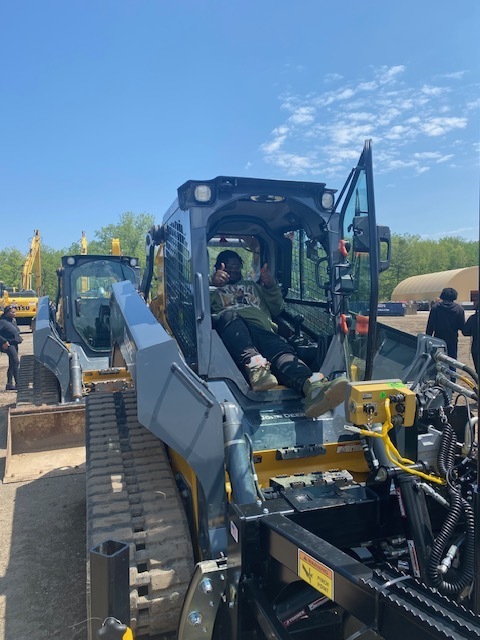 Student relaxing inside the cab of an AIS front loader