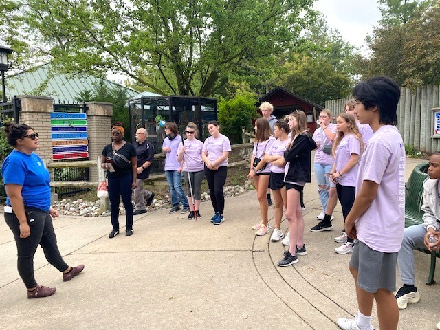 A zoo represetative talking to students at the Zoo entrace