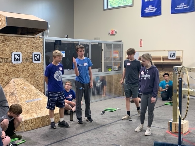 Group of stduents talking. Four are standing and three are seated