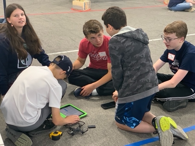 Group of 5 students sitting on the floor 