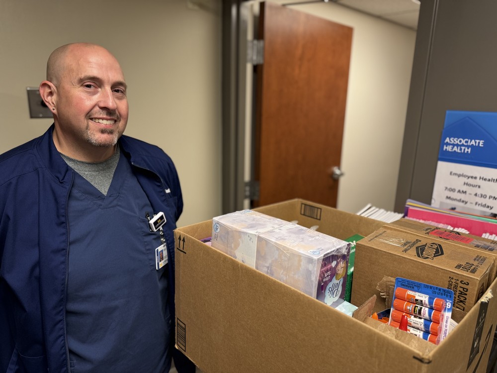 Nurse stands next to supplies being donated to classrooms in the Saginaw School District