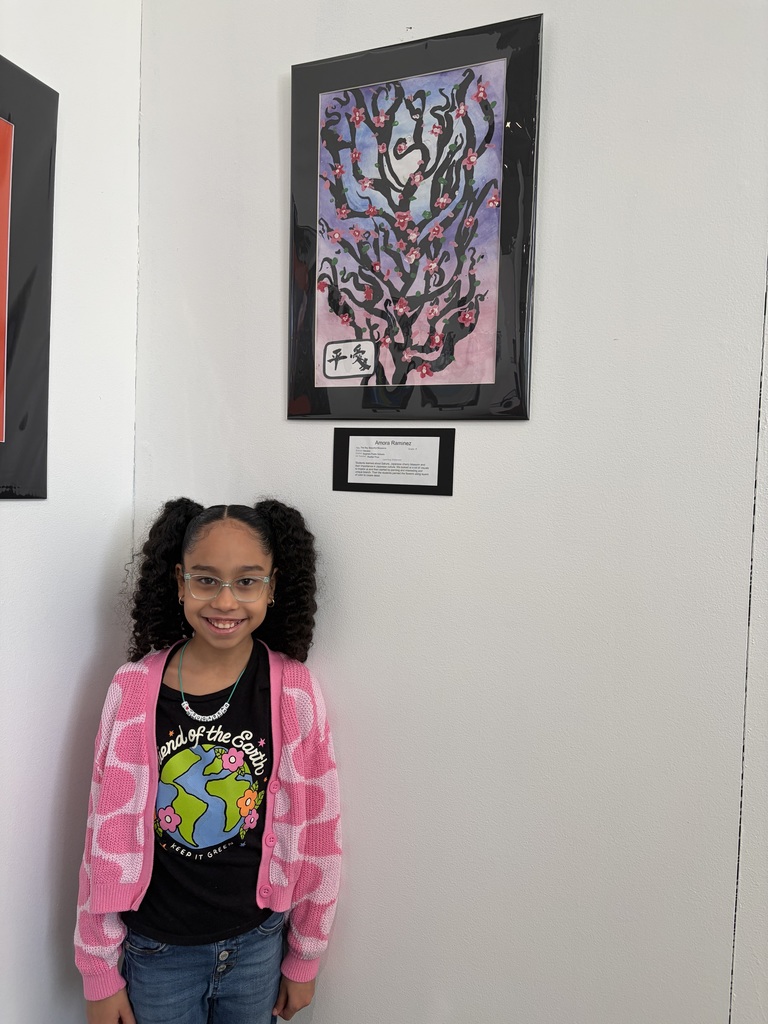 student standing by her painting of a cherry blossom